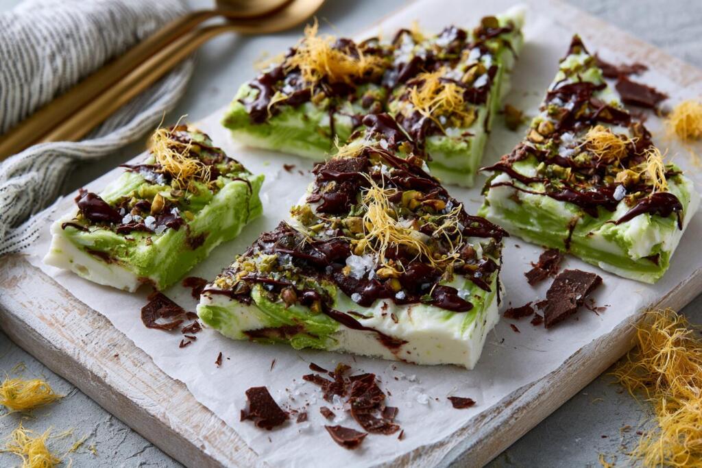 Broken pieces of Dubai chocolate protein bark with pistachio cream swirl, kataifi and dark chocolate drizzle