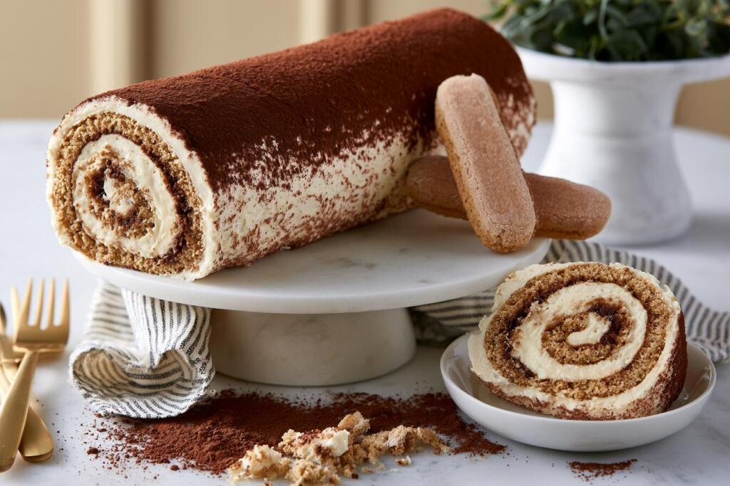 Tiramisu protein roll cake sliced to show the spiral mascarpone cream cross-section